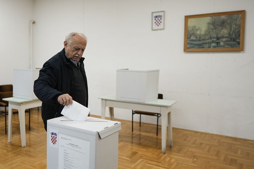 Un homme dépose son bulletin de vote dans un bureau de vote de la capitale Zagreb, le 29 décembre 2024.