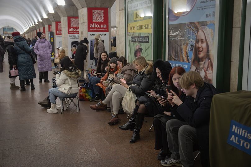 Des gens se cachent dans une station de métro lors d'une alerte d'attaque de missile russe la veille de Noël à Kiev, le 24 décembre 2024.