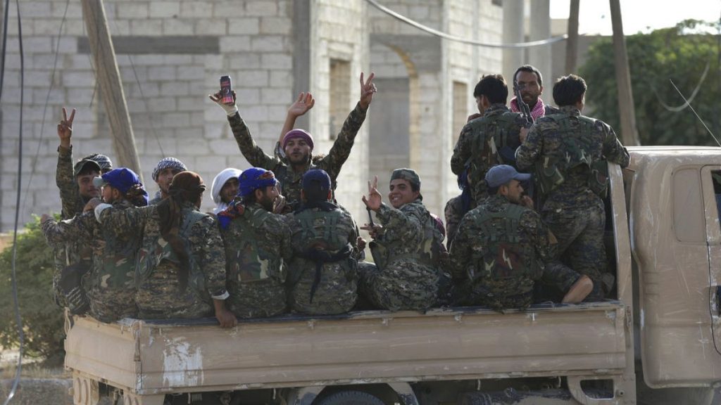 FILE - July 22, 2017, Arab and Kurdish fighters with the U.S.-backed Syrian Democratic Forces (SDF), gather on a pickup as they move to the front line against Islamic State