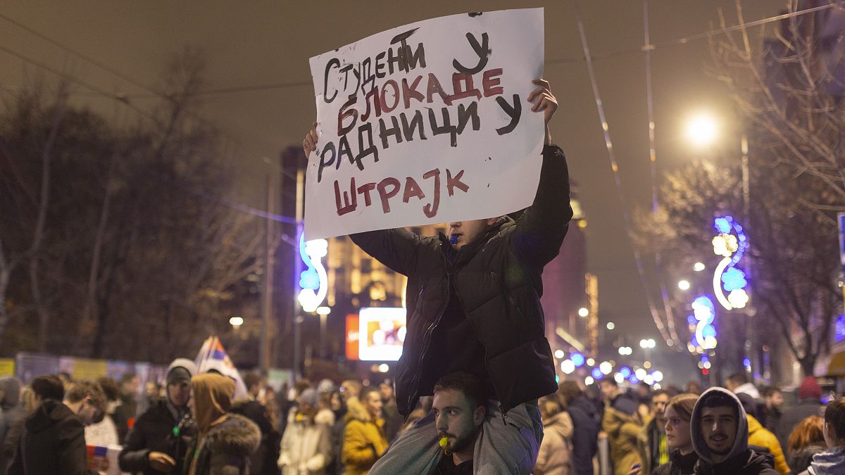 Protesters hold a banner reading ‘Students to the blockades, workers to strike’ outside the state television building in Belgrade, 12 December, 2024