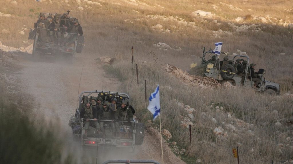 Israeli soldiers cross the security fence moving towards the so-called Alpha Line that separates the Israeli-annexed Golan Heights from Syria, in the town of Majdal Shams.