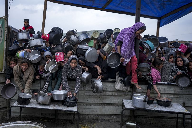 Des femmes et des filles palestiniennes luttent pour trouver de la nourriture dans un centre de distribution à Khan Younis, dans la bande de Gaza, le vendredi 20 décembre 2024.