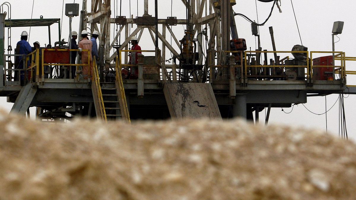 Library picture of oil workers standing on a rig in the Sakhir, Bahrain, desert.