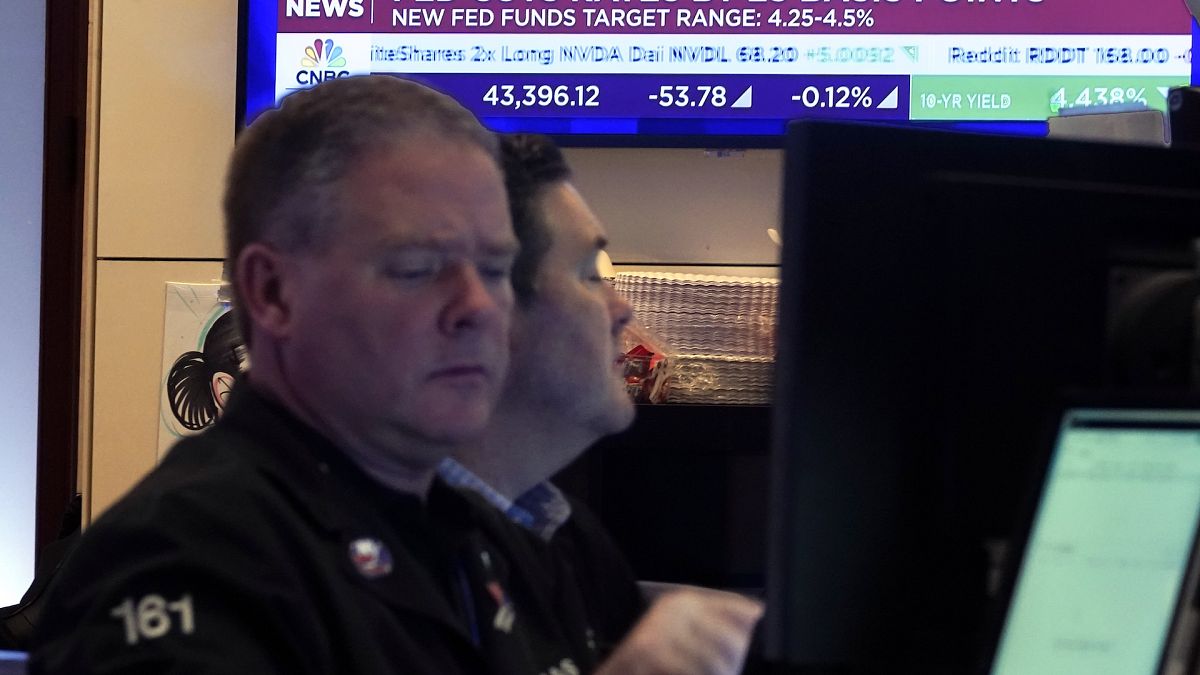 A pair of traders work on the floor of the New York Stock Exchange as the rate decision of the Federal Reserve is announced