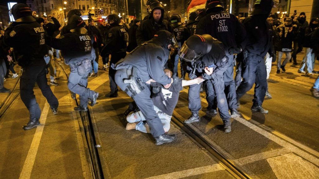 A man is taken away by police officers during a demonstration by right-wing groups in Magdeburg, Germany, Saturday, Dec. 21, 2024. (Christoph Soeder/dpa via AP)