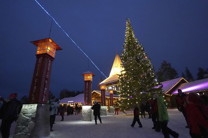 Des touristes visitent le village du Père Noël, un parc d'attractions sur le thème de l'hiver perché au bord du cercle polaire arctique, à Rovaniemi, en Finlande, le mercredi 4 décembre 2024. 