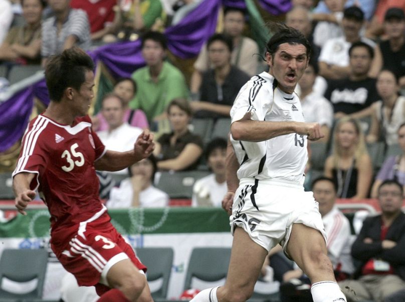   Mikheil Kavelashvili, à droite, tire vers le but lors de la Coupe de la Réunification contre l'équipe nationale chinoise à Hong Kong, le 1er juillet 2007.