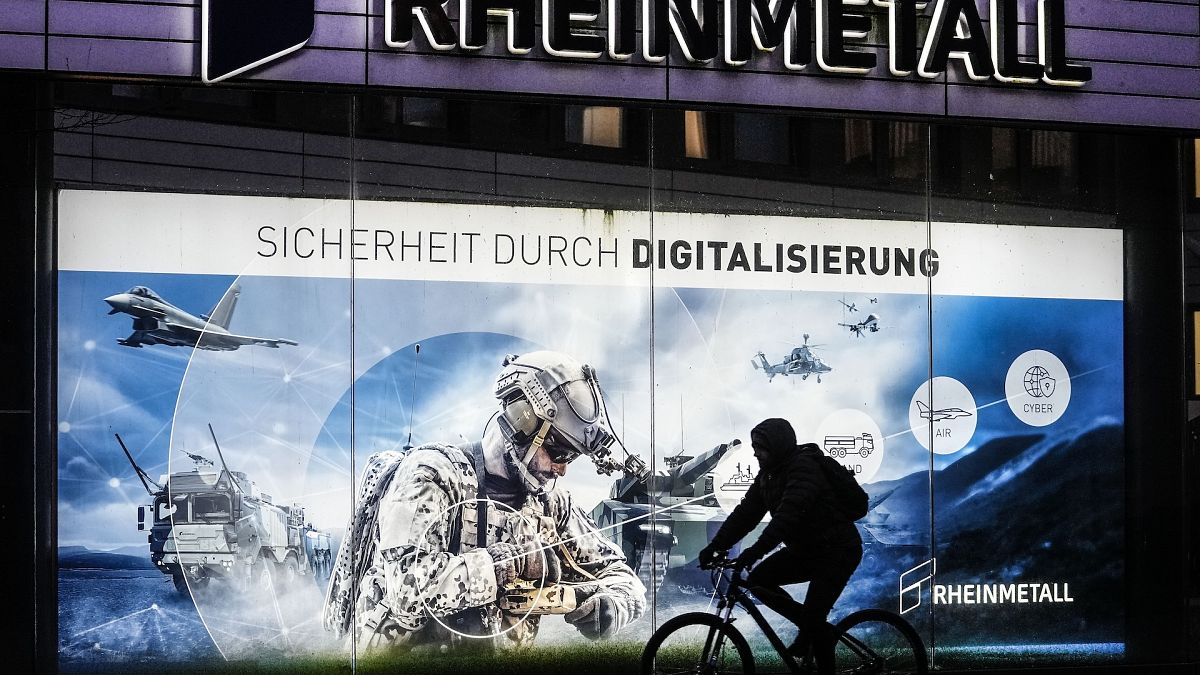 A man on a bicycle passes the headquarters of Germany