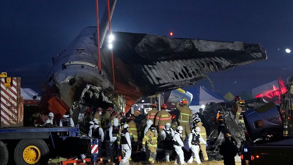 Rescue team carry the body of a passenger at the site of a plane fire at Muan International Airport in Muan, South Korea, Sunday, Dec. 29, 2024.