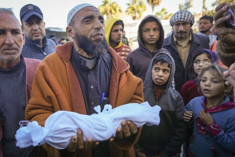 L'imam Islam Abu Suaied tient le corps de Jomaa al-Batran, 20 jours, décédé d'hypothermie, avant les funérailles à l'hôpital des martyrs d'Al-Aqsa, dans le centre de Gaza, dimanche 29 décembre.