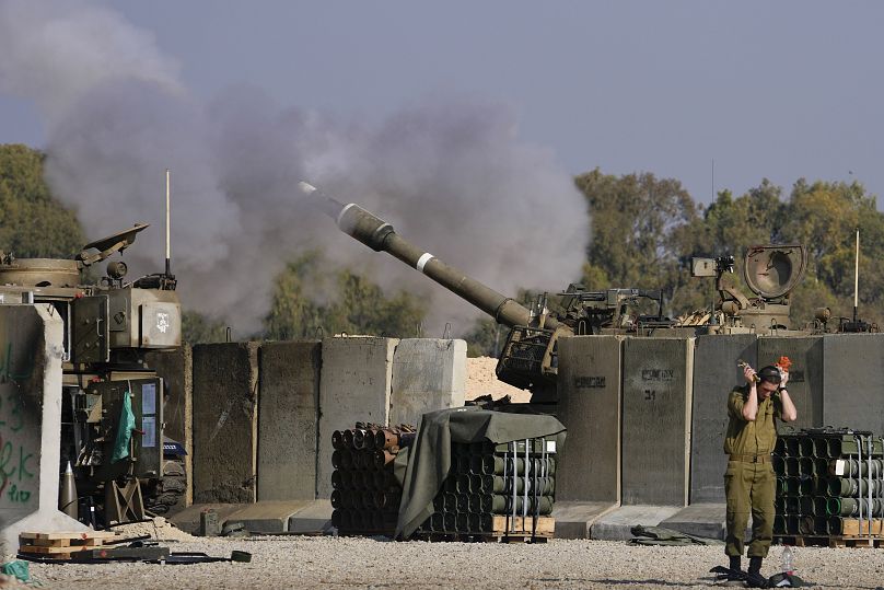 Un soldat israélien se bouche les oreilles alors qu'un artilleur tire sur la bande de Gaza depuis une position dans le sud d'Israël, le 2 janvier 2025.