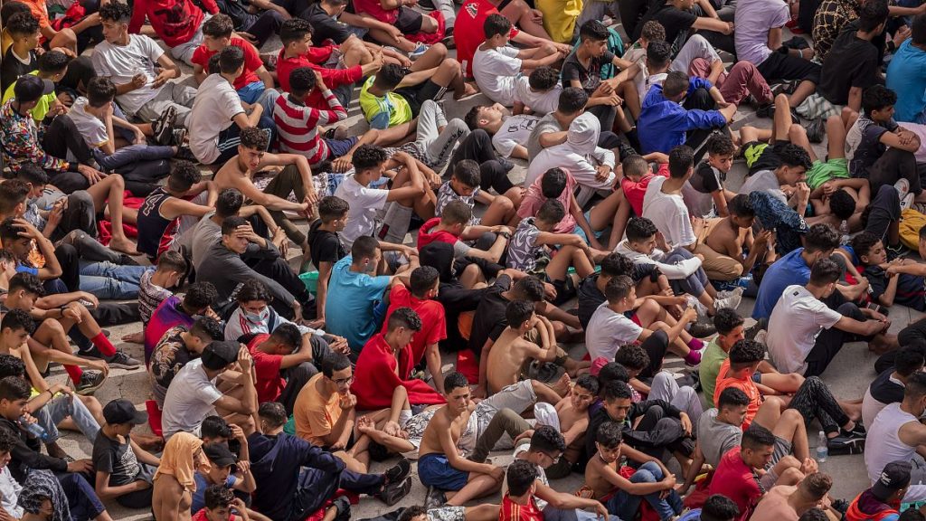 Unaccompanied minors who crossed into Spain are gathered outside a temporary shelter at the Spanish enclave of Ceuta near the border of Morocco, 19 May, 2021