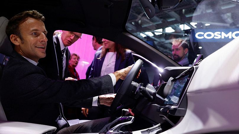 Le président français Emmanuel Macron est assis à bord d'une Peugeot EV au Salon automobile de Paris, octobre 2022. 