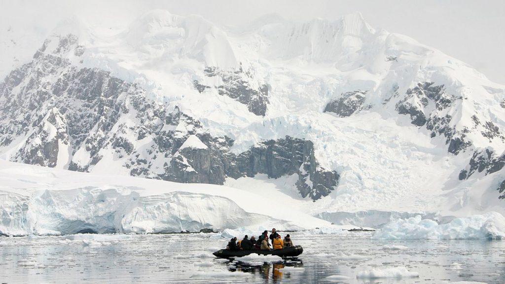 Tourists get close to icebergs and the Antarctic coast during a shirt excursions on a Zodiac boat in Brown Bluff, Antarctica.