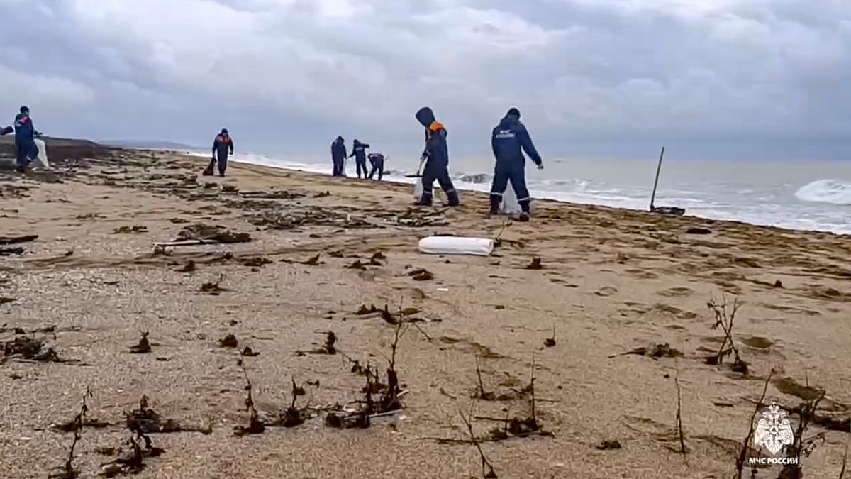 Workers clean up tons of fuel oil that spilled out of two storm-stricken tankers more than two weeks ago in the Kerch Strait, 4 January, 2024