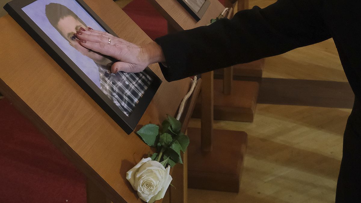 People with photos of relatives at the memorial service for the 12 victims of the Cetinje shooting, 4 January, 2025