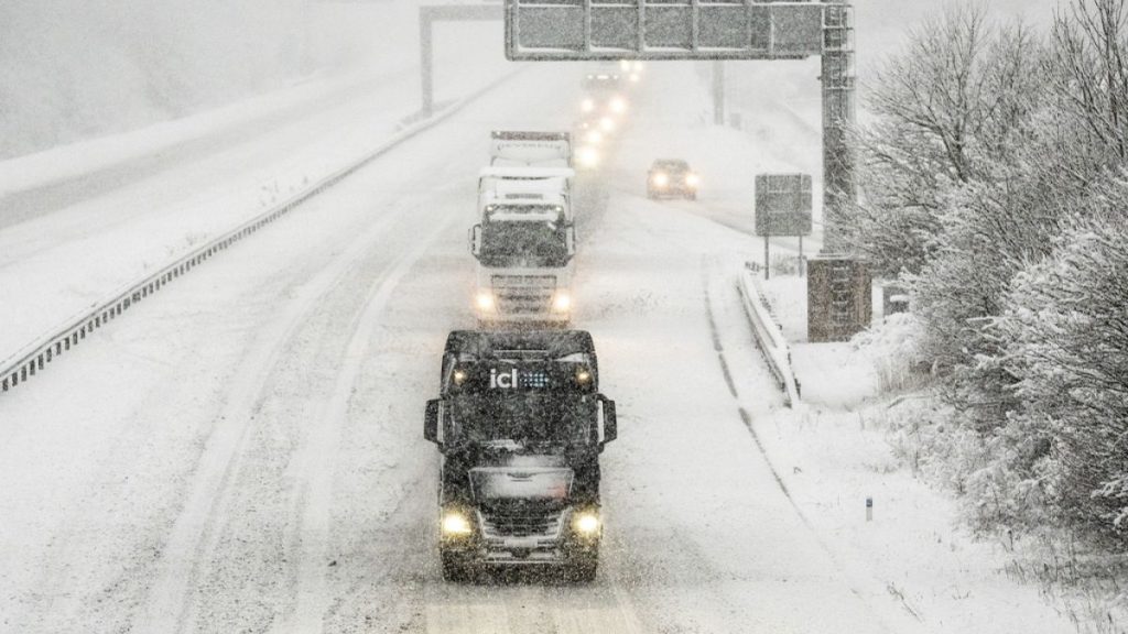 Vehicles in transit under snow in Hopperton, northern England.