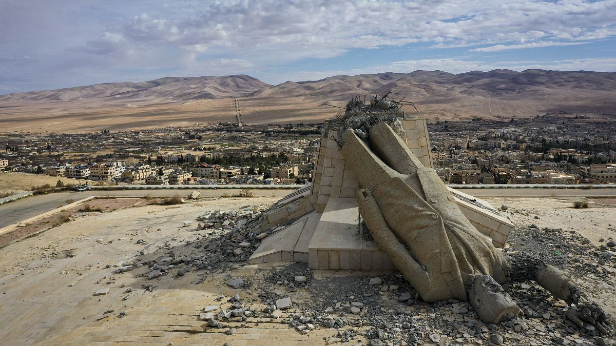 A statue of the late Syrian President Hafez al-Assad lies in ruins atop a mountain in Dayr Atiyah, 5 January, 2025