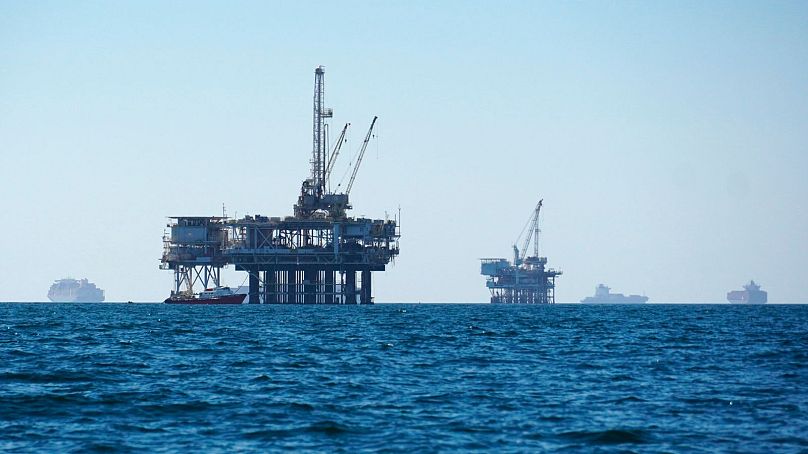 Des cargos sont vus ancrés au large, partageant l'espace avec des plates-formes pétrolières, avant de se diriger vers le port de Los Angeles-Long Beach, le 5 octobre 2021.