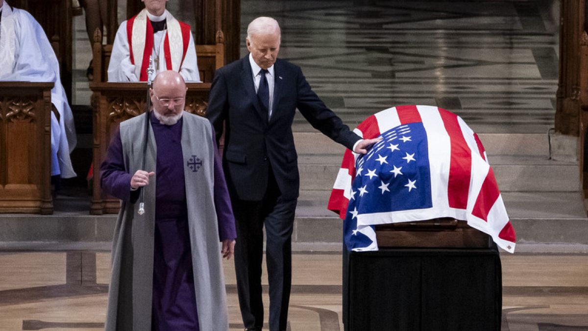 President Joe Biden touches the casket of former President Jimmy Carter after delivering remarks during Carter