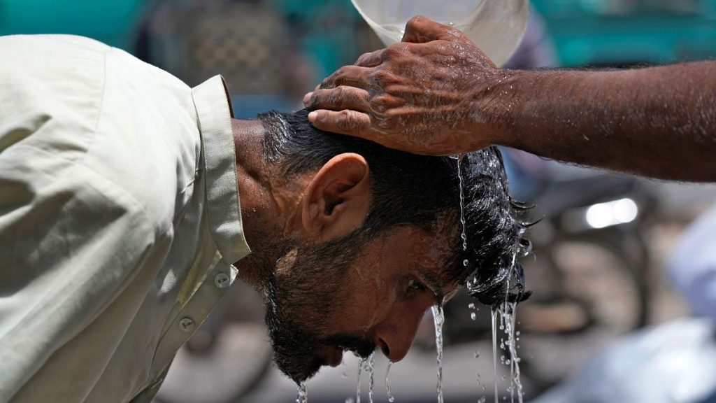 A volunteer pours water to cool a man off during a hot day in Karachi, Pakistan.