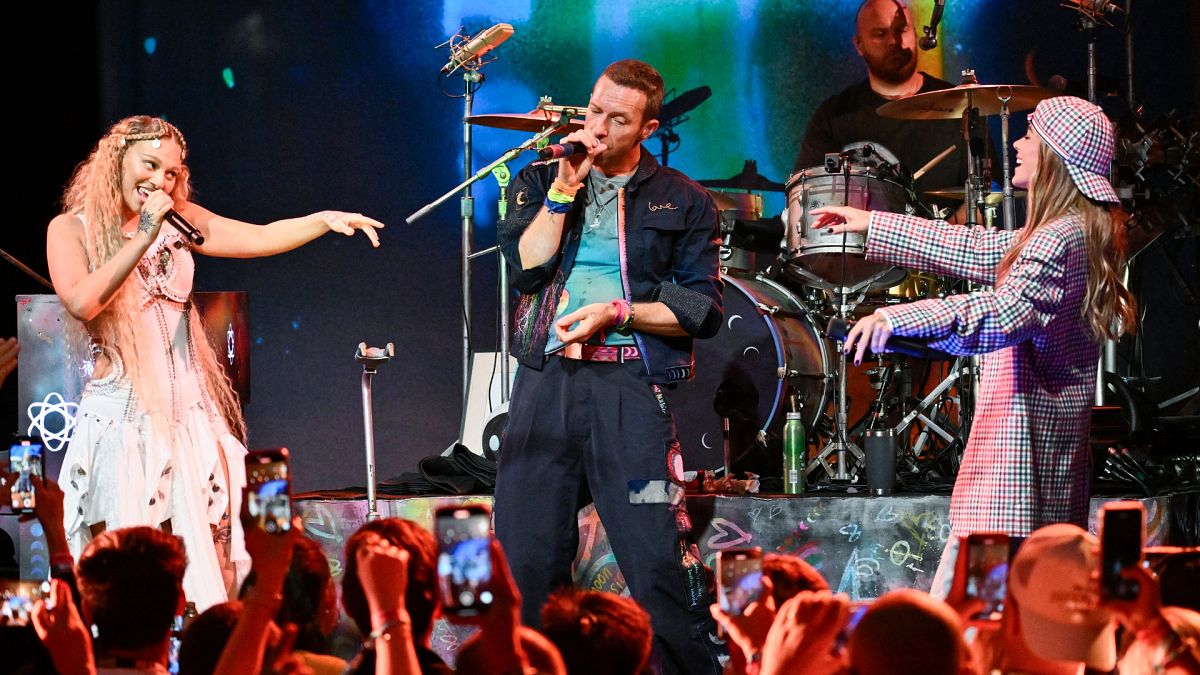 Elyanna, left, and TINI, right, perform with Chris Martin, second from left, and Will Champion of Coldplay on Monday, Oct. 7, 2024