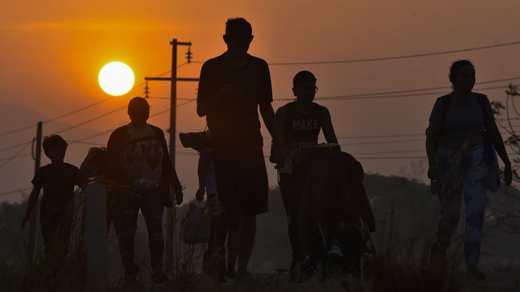 Migrants walk at sunrise along a highway in southern Mexico towards the US border, 8 January, 2024