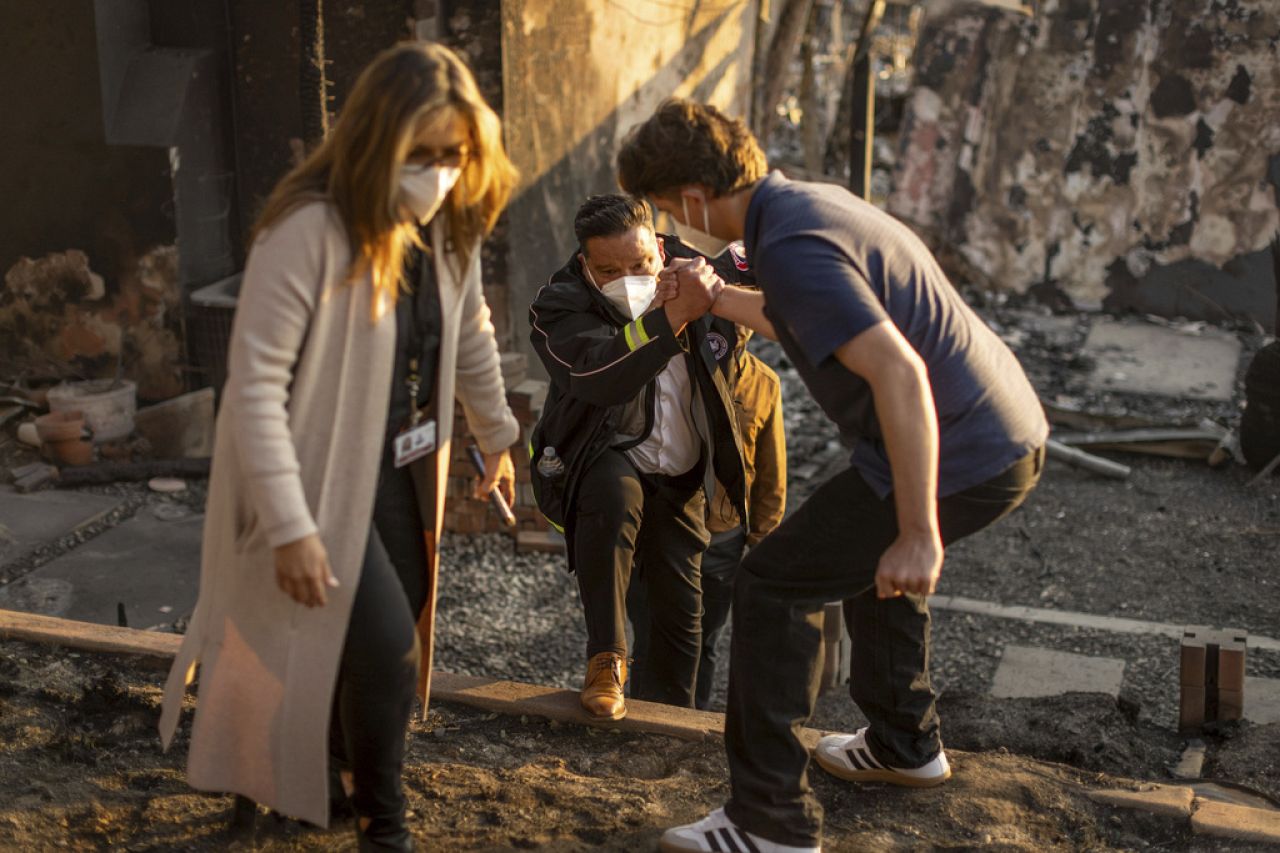 Une personne aide le maire de Pasadena, Victor Gordo, au centre, alors qu'il rencontre les victimes de l'incendie d'Eaton à Altadena, en Californie, le vendredi 10 janvier.