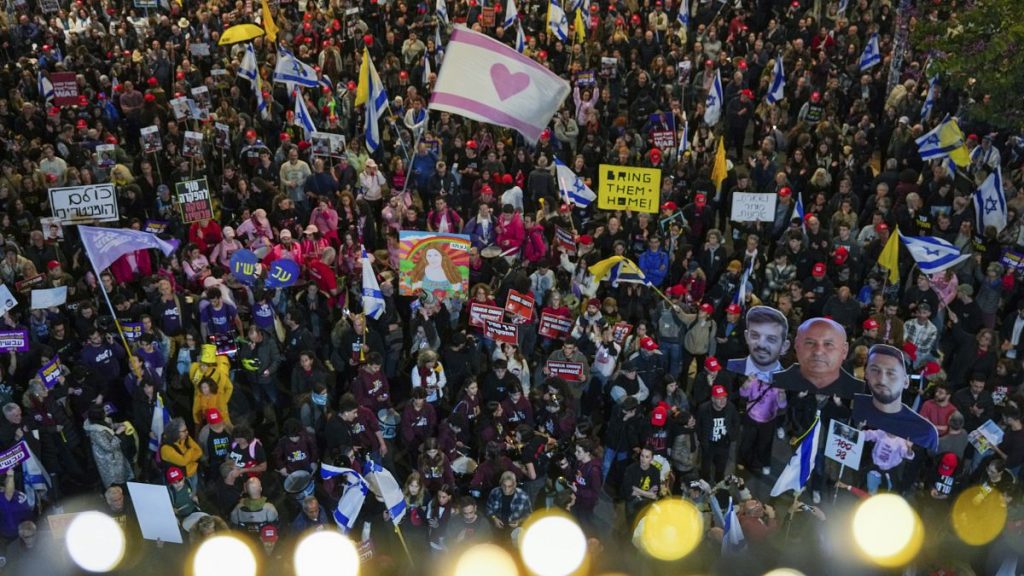 Demonstrators in Tel Aviv wave Israeli flags and signs during a protest calling for the immediate release of the hostages held in Gaza, 11 January, 2025