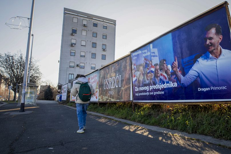 Un piéton passe devant une affiche de campagne pour le challenger présidentiel Dragan Primorac à Zagreb, le 26 décembre 2024