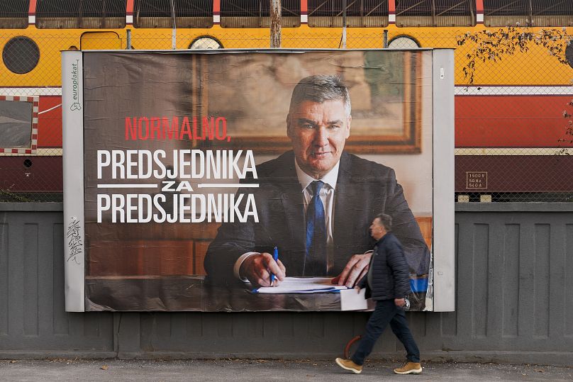 Un piéton passe devant une affiche de campagne du président Zoran Milanovic à Zagreb, le 7 janvier 2025.