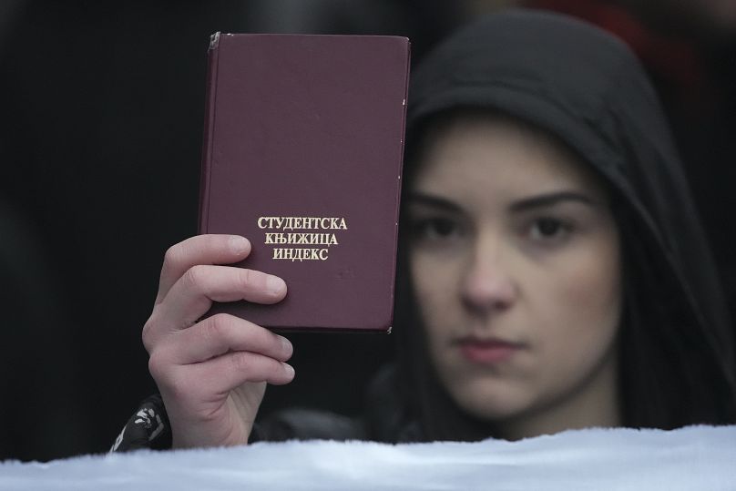 Une jeune fille tient un livret d'étudiant devant la Cour constitutionnelle de Serbie à Belgrade, le 12 janvier 2025.