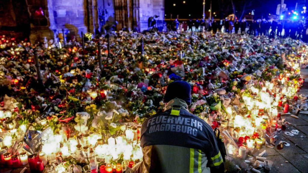 Flowers are laid in front of the Johannis church near the Christmas Market in Magdeburg, Germany, Monday, Dec. 23, 2024