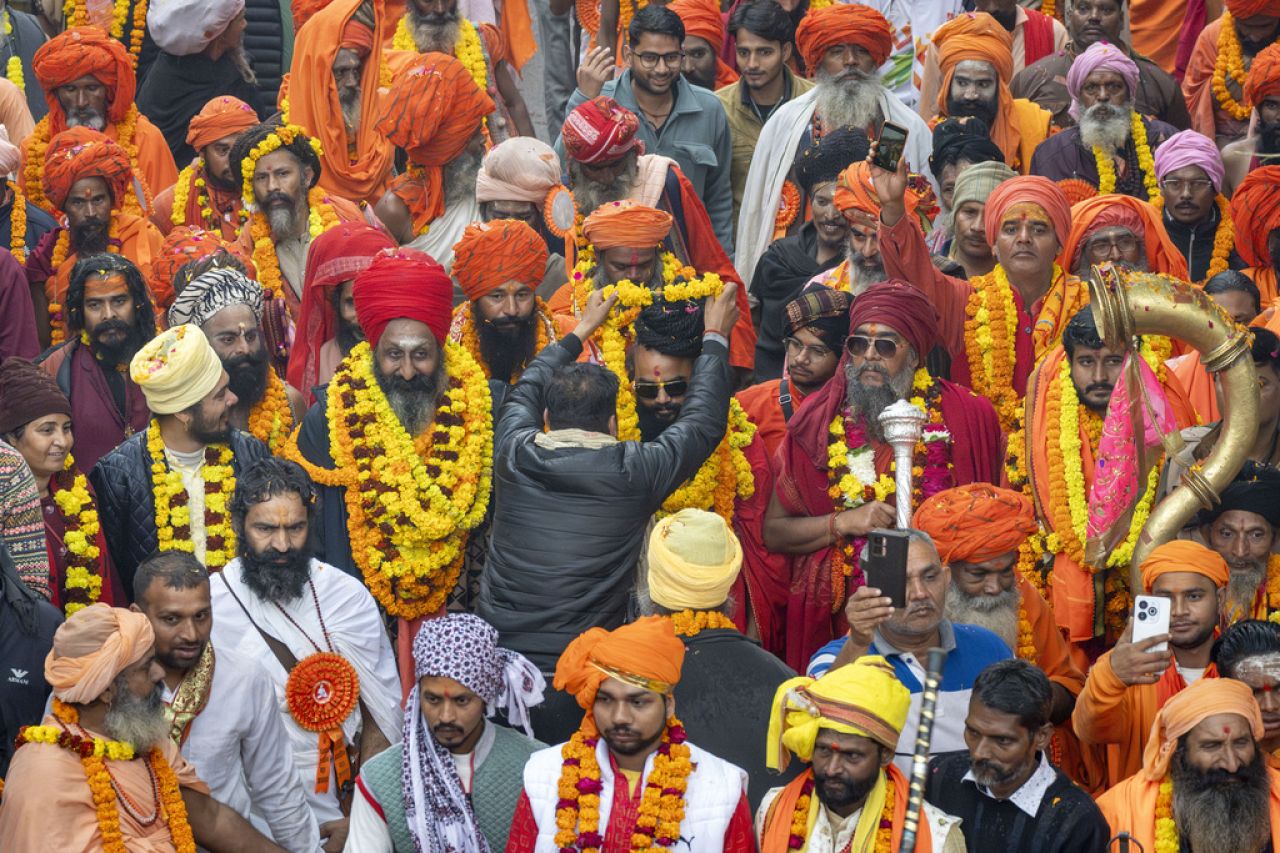 Un dévot guirlandes un saint homme hindou marchant dans une procession, un jour avant le festival Maha Kumbh, qui dure 45 jours, à Prayagraj.