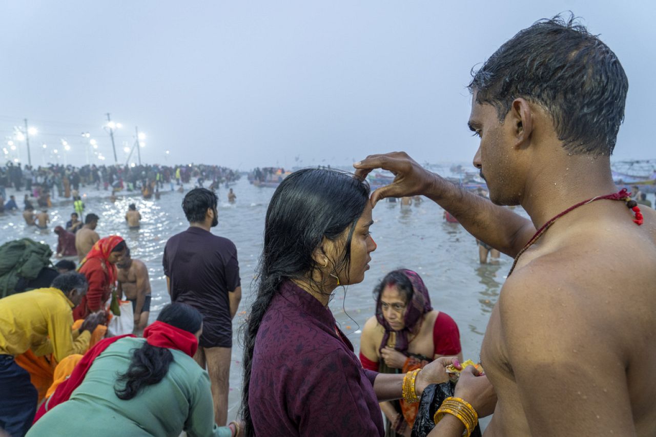 Un dévot hindou appose une marque vermillon sur le front de sa femme après s'être baigné au confluent du Gange, de la Yamuna et des mythiques rivières Saraswati.