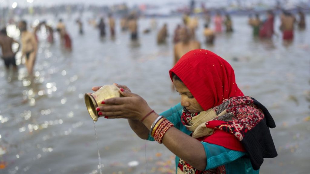 A Hindu devotee prays before taking a dip at the confluence of the Ganges, the Yamuna and the mythical Saraswati rivers on the first day of the 45-day-long Maha Kumbh festival