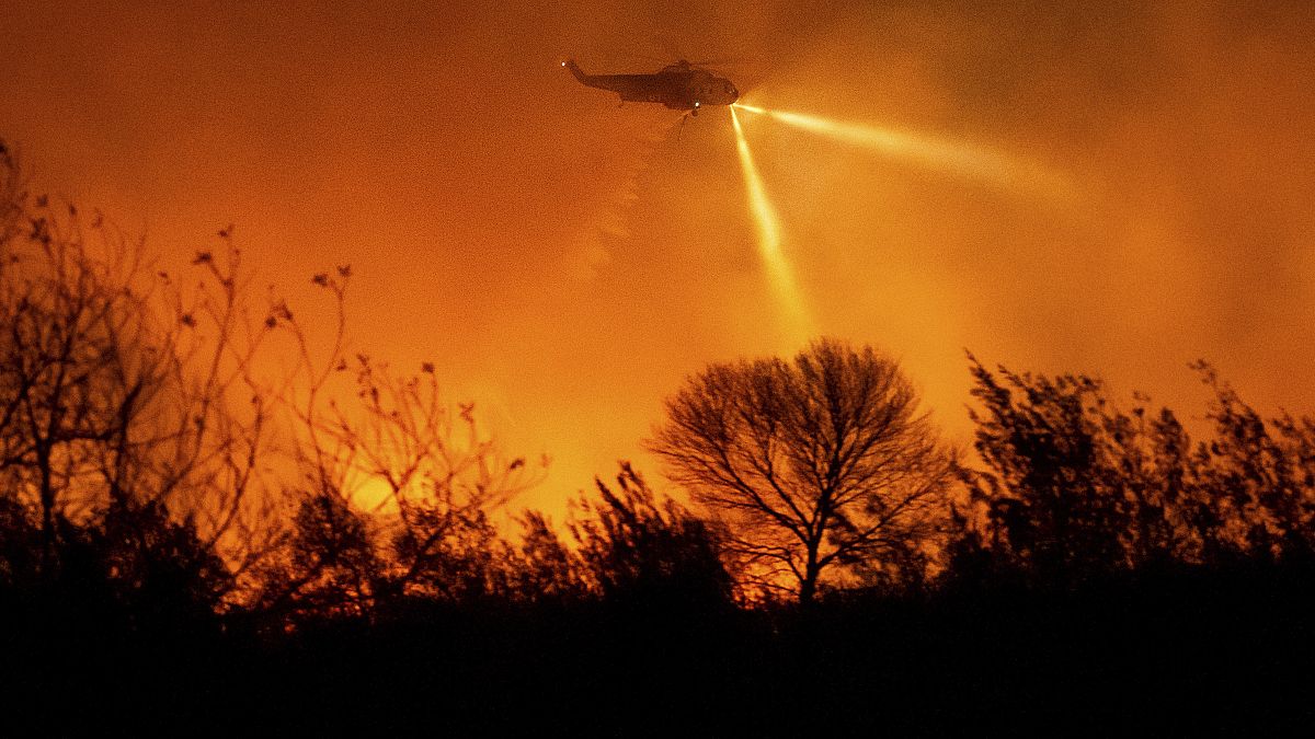 A helicopter drops water while fighting the Auto Fire in Ventura County.