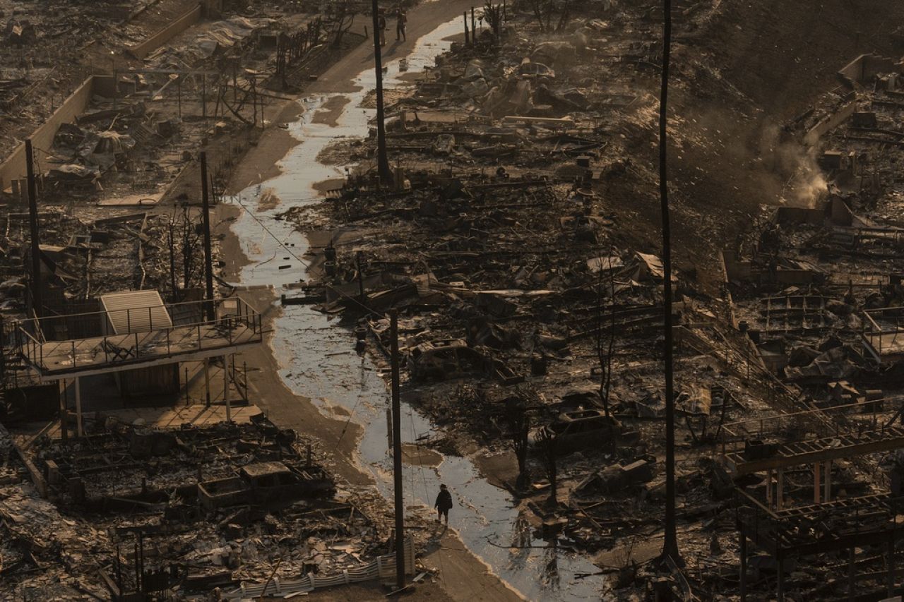 Une personne marche au milieu des destructions laissées par l’incendie de Palisades dans le quartier Pacific Palisades de Los Angeles, le 9 janvier 2025.