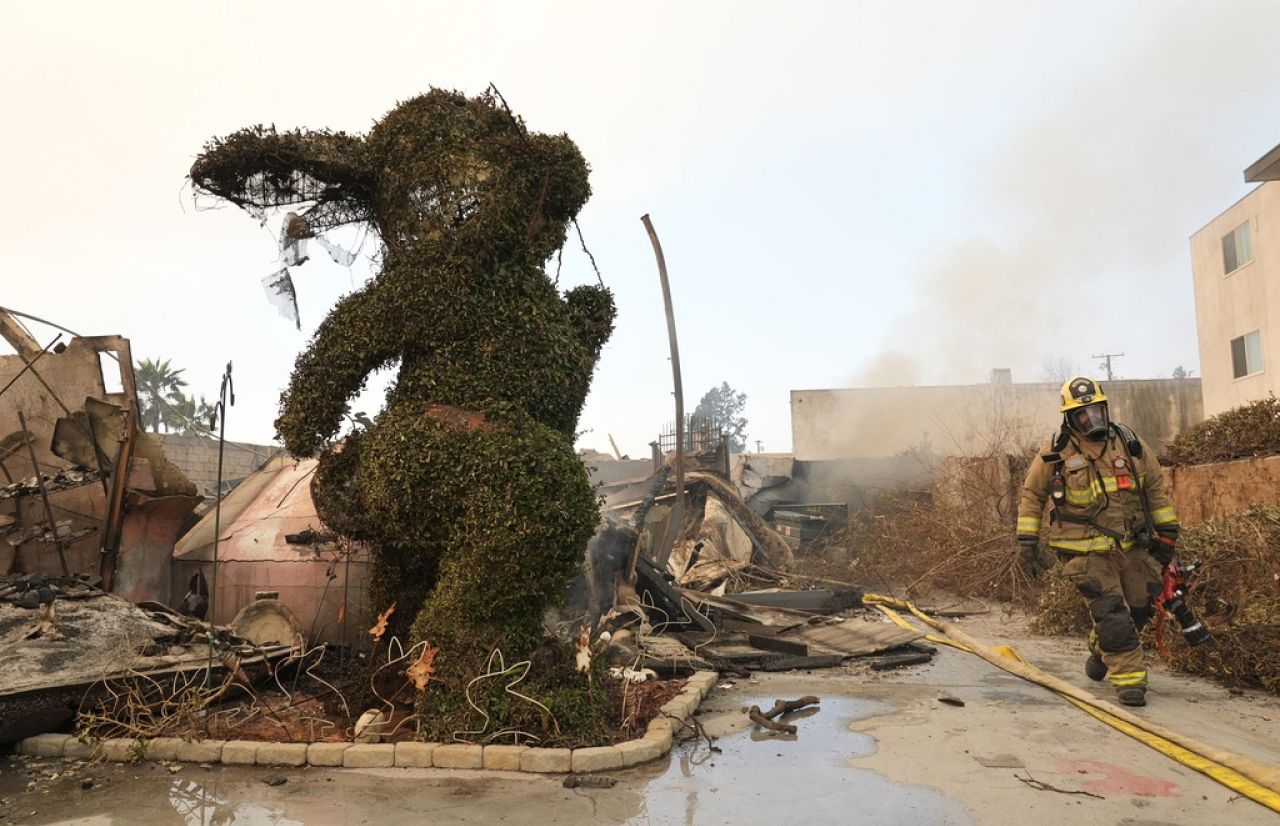 Un pompier passe devant une sculpture de lapin carbonisé et des débris au musée du lapin détruit, le 9 janvier 2025, à Altadena, en Californie.