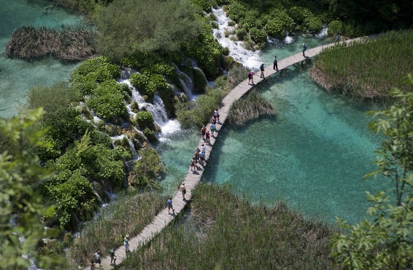 Les touristes traversent un pont dans le parc national de Plitvice, en Croatie centrale