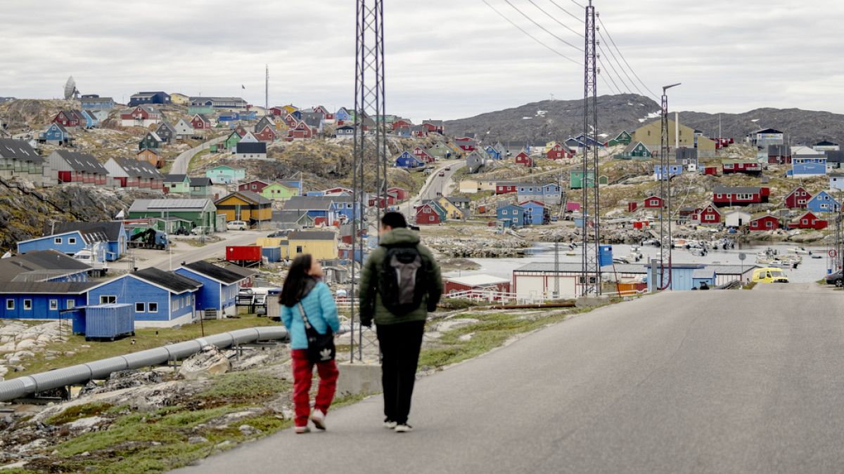 People walk in the town of Aasiaat, in western Greenland, located on its namesake island in the heart of Aasiaat Archipelago in Greenland, Saturday, June 29, 2024.