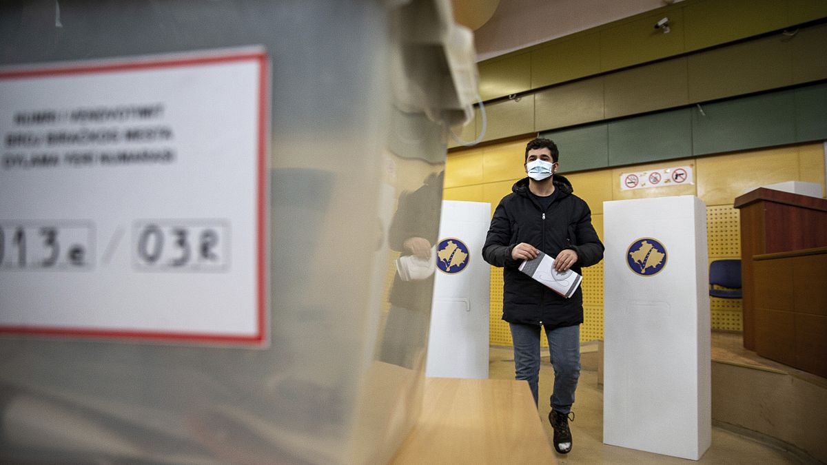 A man holds his ballot paper to cast in parliamentary elections in the capital Pristina, 14 February, 2021