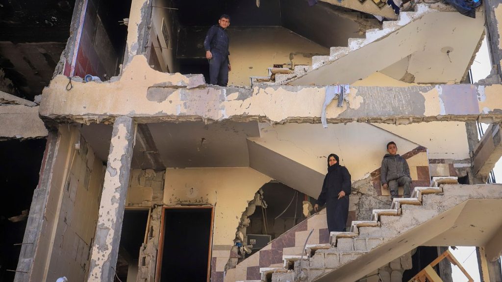 Palestinians inspect a building damaged by the Israeli offensive in Rafah, southern Gaza Strip, Monday, Jan. 20, 2025.