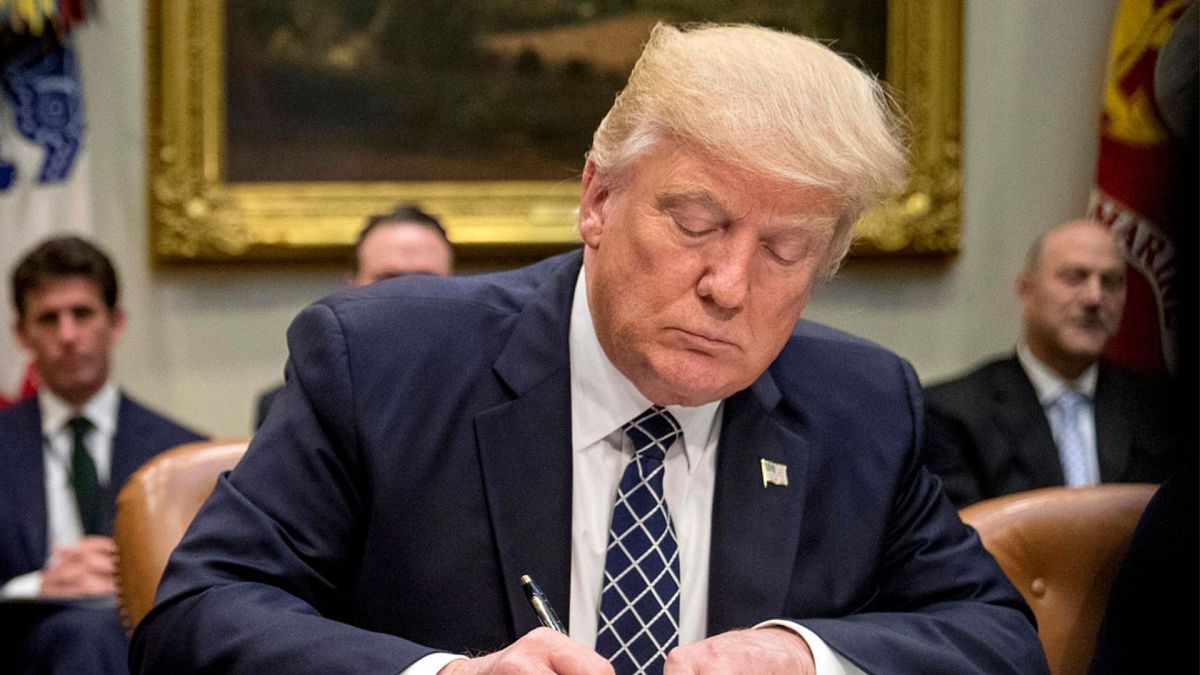 FILE - President Donald Trump signs an executive order in the Roosevelt Room of the White House in Washington, April 25, 2017. (AP Photo/Andrew Harnik, File)