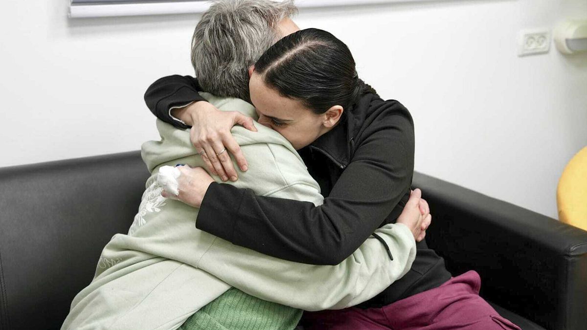 photo released by the Israeli Army, Emily Damari, right, and her mother Mandy embrace near kibbutz Reim, southern Israel after Emily was released from captivity by Hamas