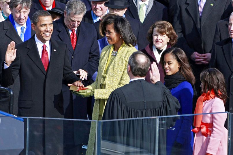 Barack Obama prête serment devant le juge en chef John Roberts en tant que 44e président des États-Unis, sous le regard de son épouse Michelle, le mardi 20 janvier 2009 à Washington.