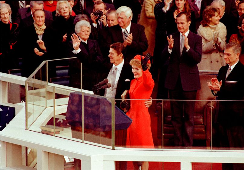 Le président américain Ronald Reagan et son épouse, la première dame Nancy Reagan, saluent la foule sur la façade ouest du bâtiment du Capitole à Washington, DC.