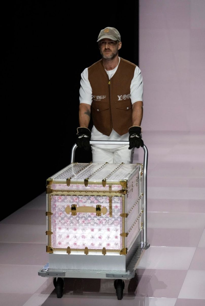 Un homme présente une valise de la collection homme Louis Vuitton Automne-Hiver 2025-2026