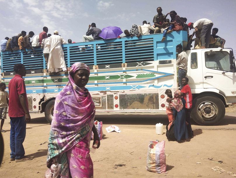 Des gens montent à bord d’un camion alors qu’ils quittent Khartoum, Soudan, 2023.