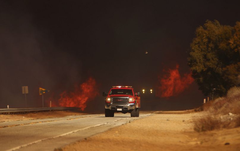 Un camion de pompiers passe devant les flammes causées par l'incendie de Hughes à Castaic, en Californie, le mercredi 22 janvier 2025.